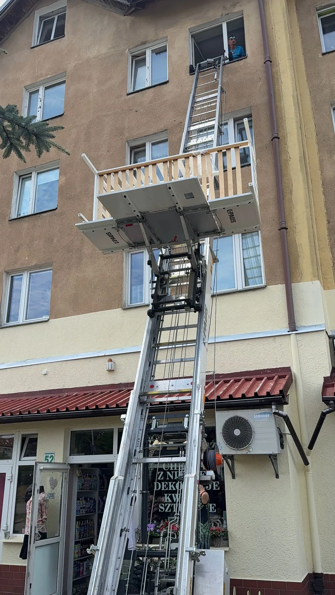 Winda PAUS z platformą uniesioną na wysokość okna kamienicy - Szczecin